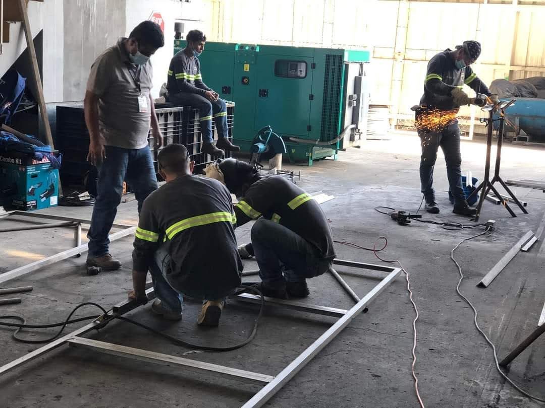 Equipo de IMEC trabajando con equipo de protección personal en un montaje industrial